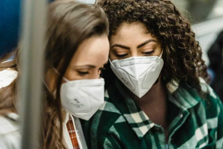 Zwei Frauen mit Masken auf Mund und Nase