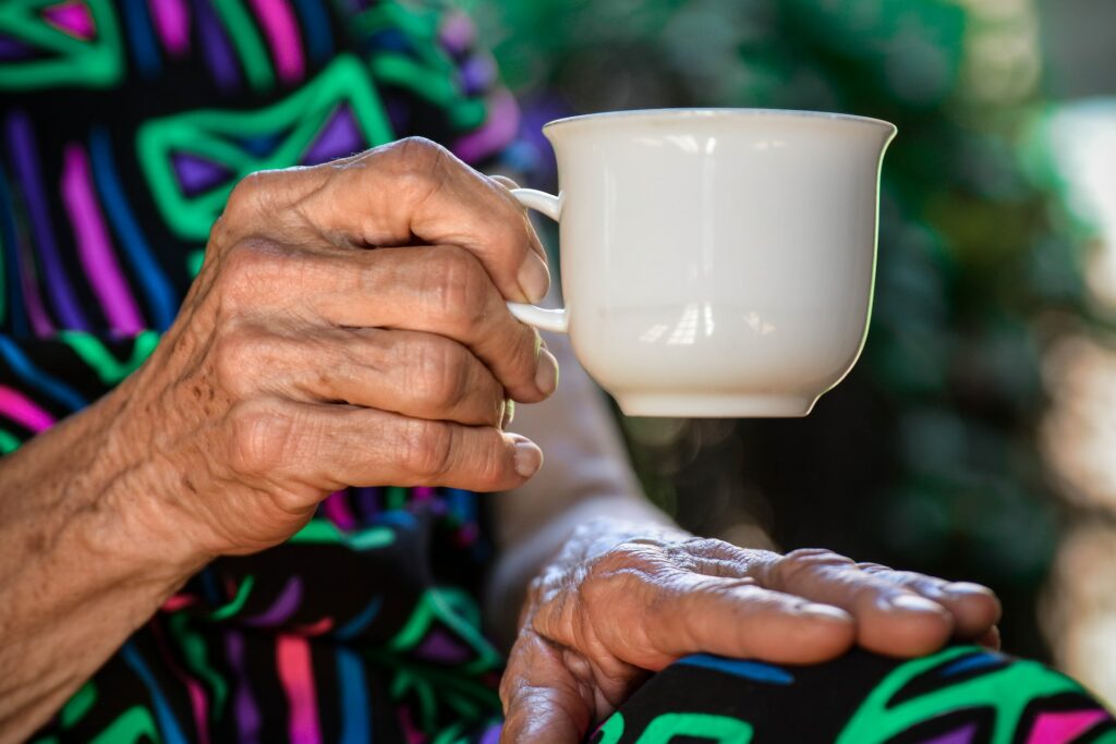 Eine Tasse wird von einer älteren Frau gehalten