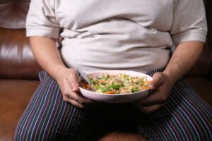 Dicker Mann mit Salat in der Hand