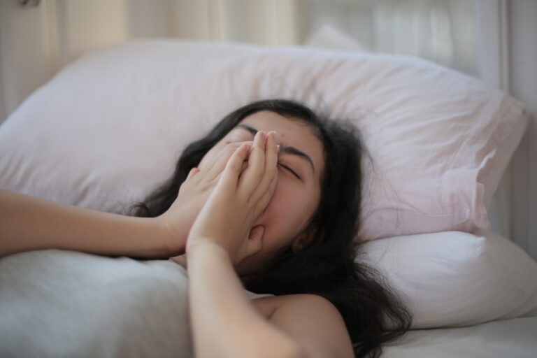 Müde Frau am Gähnen im Bett