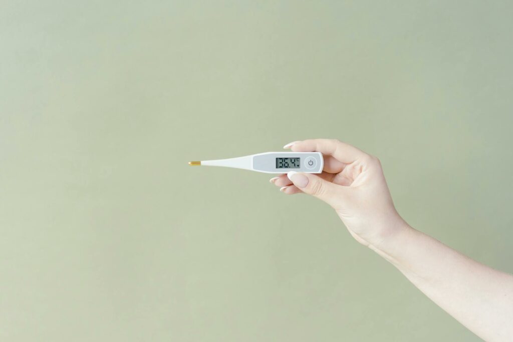 Fieber-Thermometer in der Hand eines Menschen