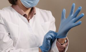 Ärztin mit Handschuhen und Mundschutz