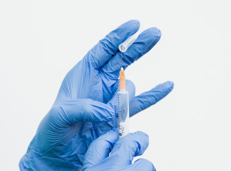 Spritze in Händen mit Handschuhen