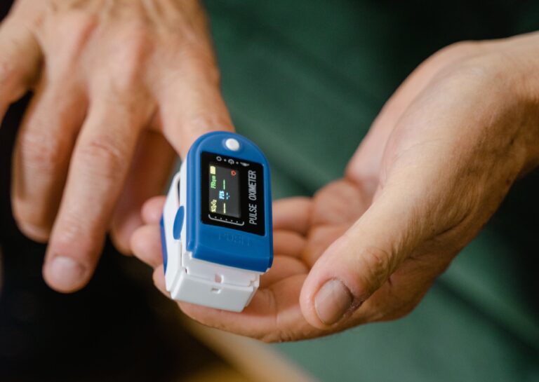 Mensch testet auf einem Finger Puls mit Pulsoximeter