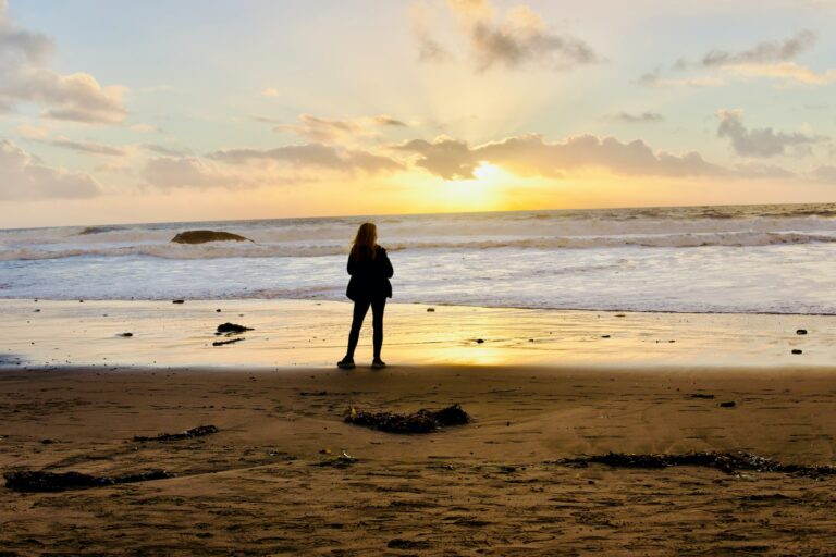 Frau am Strand bei Sonnenuntergang