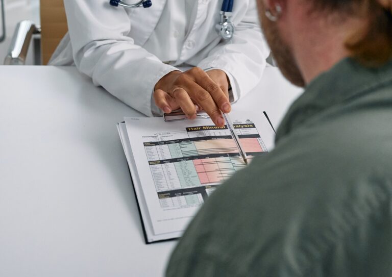 Arzt zeigt auf Laborbefund für Patienten