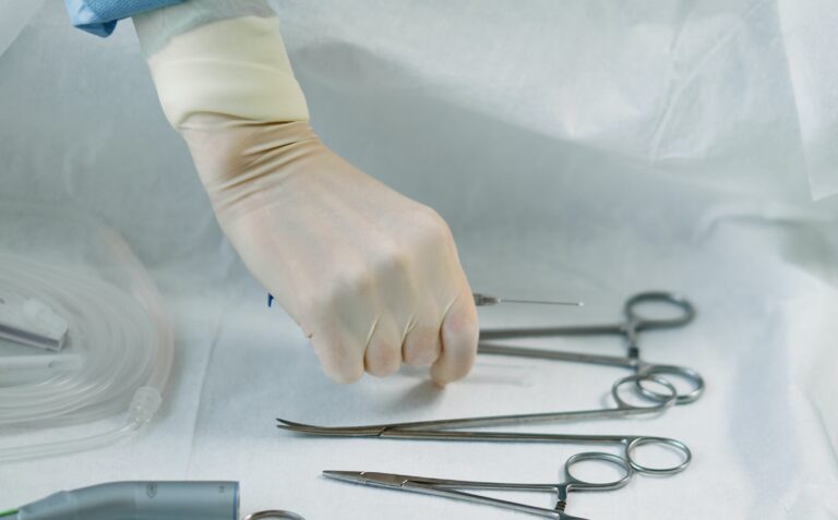Hand in Handschuhen greift nach Op-Material