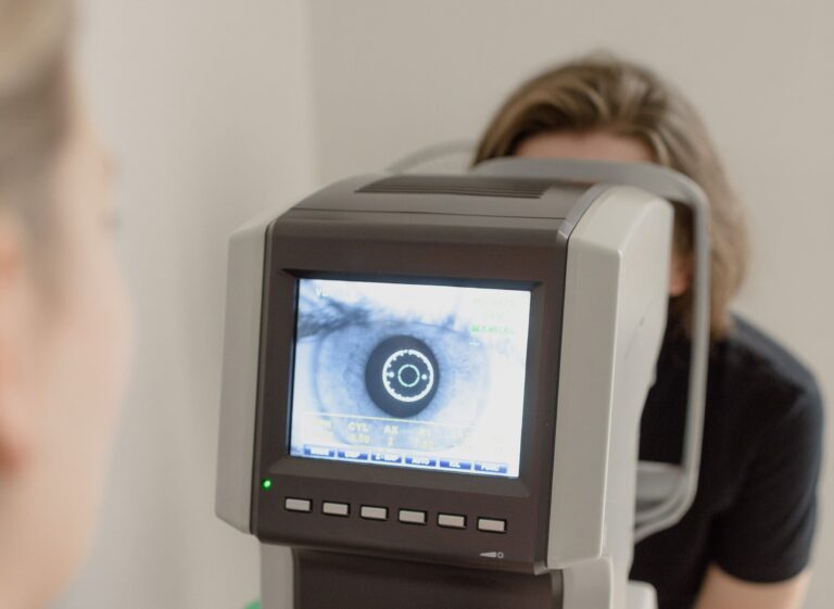 Augenarzt guckt sich ein Auge eines Patienten an