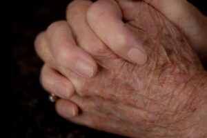 Ältere Frau faltet ihre Hände