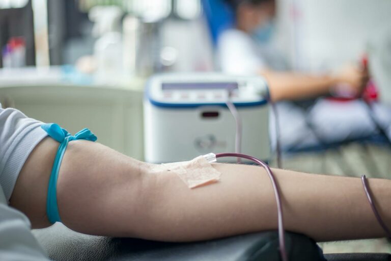 Person wird Blut im Arm abgenommen