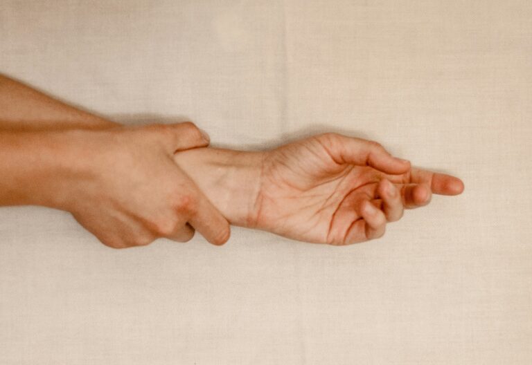 Person hält sich das Handgelenk und den Unterarm